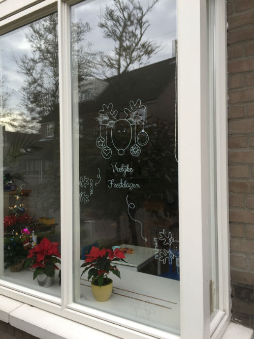 Raamtekening voor de feestdagen - kerstkaart op het raam